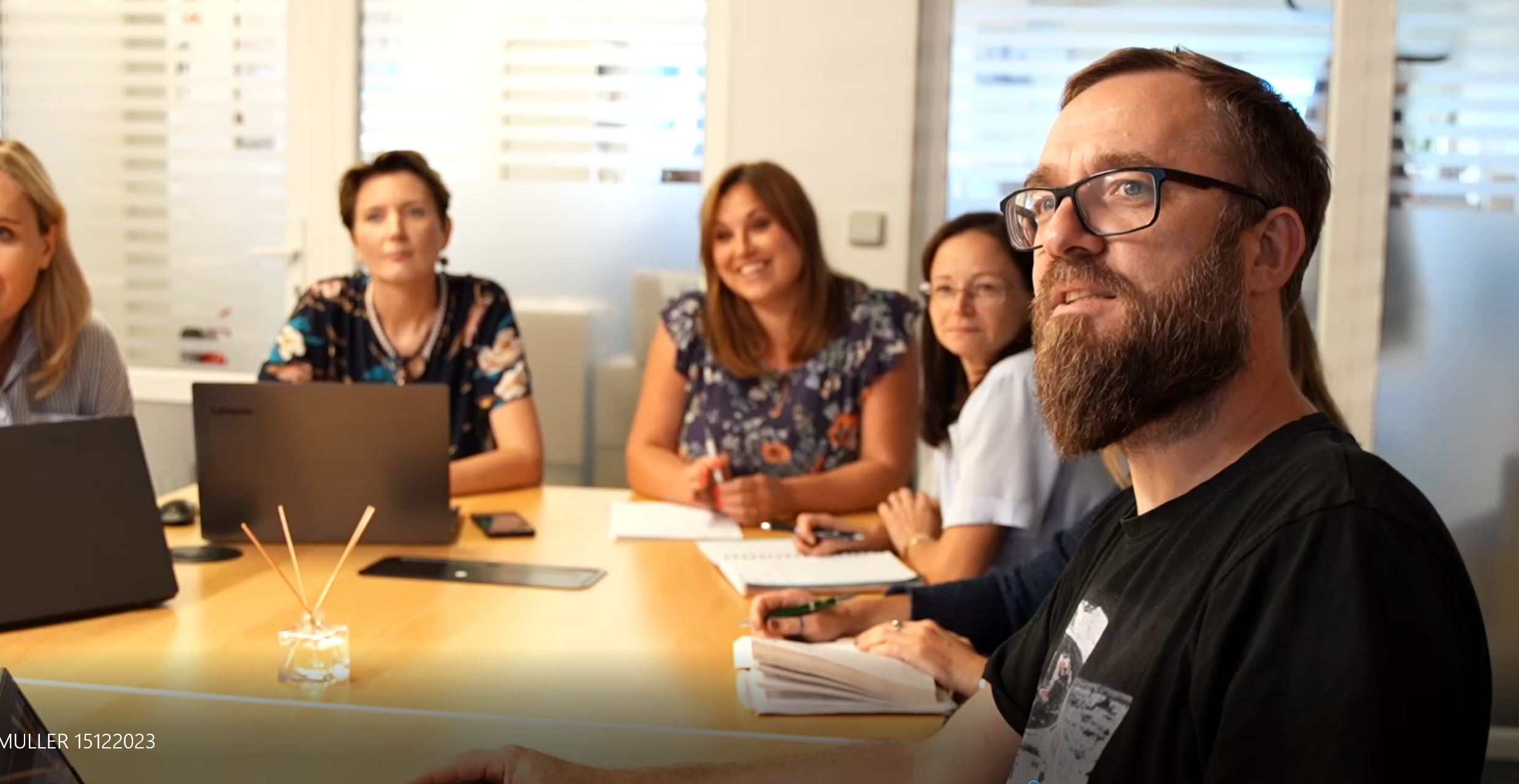 Team members are sitting together at a meeting at Müller Kerzen
