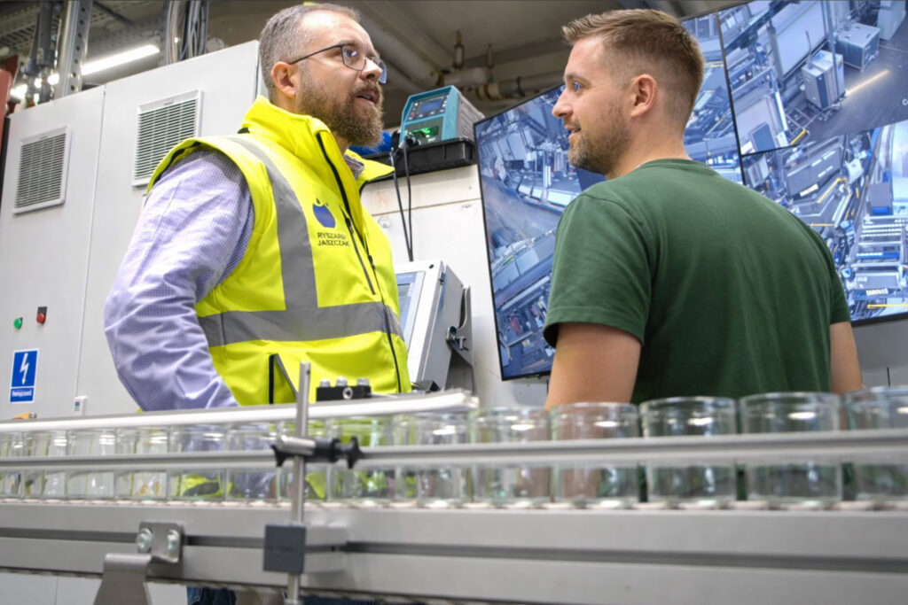 Employees monitor the production of candle glasses.